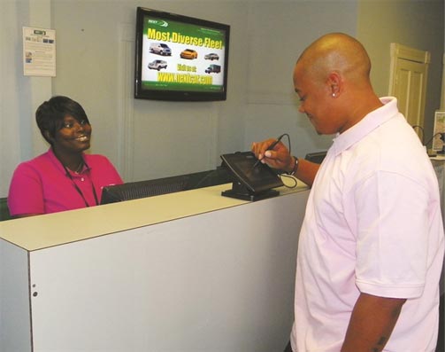 A NextCar customer uses the e-signature pad to review and approve his rental agreement. Photo credit: NextCar